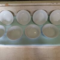 Piattini bianchi per dolce, posate, tazze cappuccino con piattino.